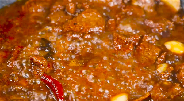 改中小火煮牛肉片刻，再加入干辣椒继续闷煮。加入辣椒酱在其中然后搅匀，继续煮。