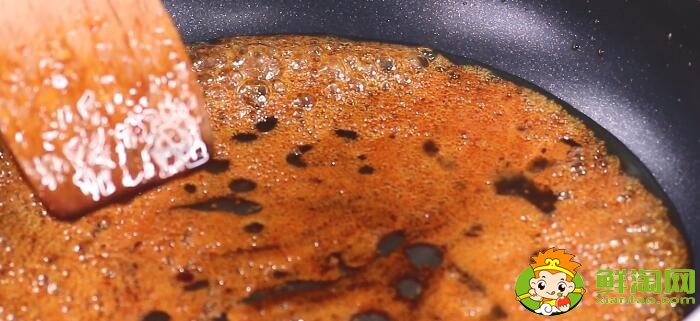 在锅中加入油和少量白糖，以中小火不停的翻炒，炒好的糖浆呈现为红色。